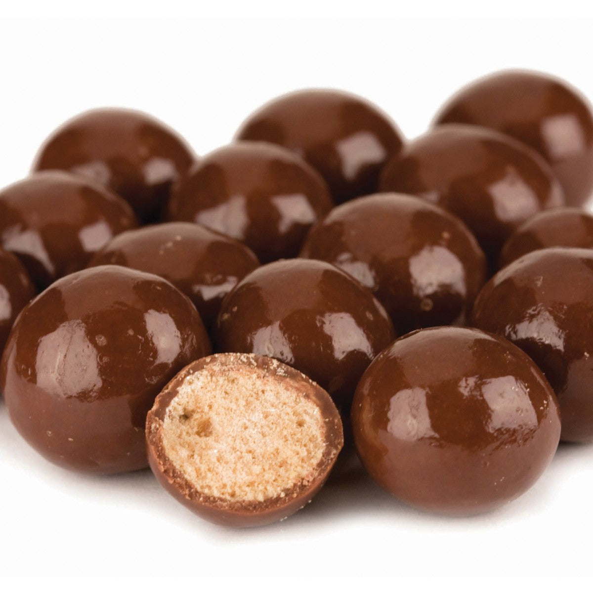 Chocolate-covered candies with one halved to reveal a textured center on a white background
